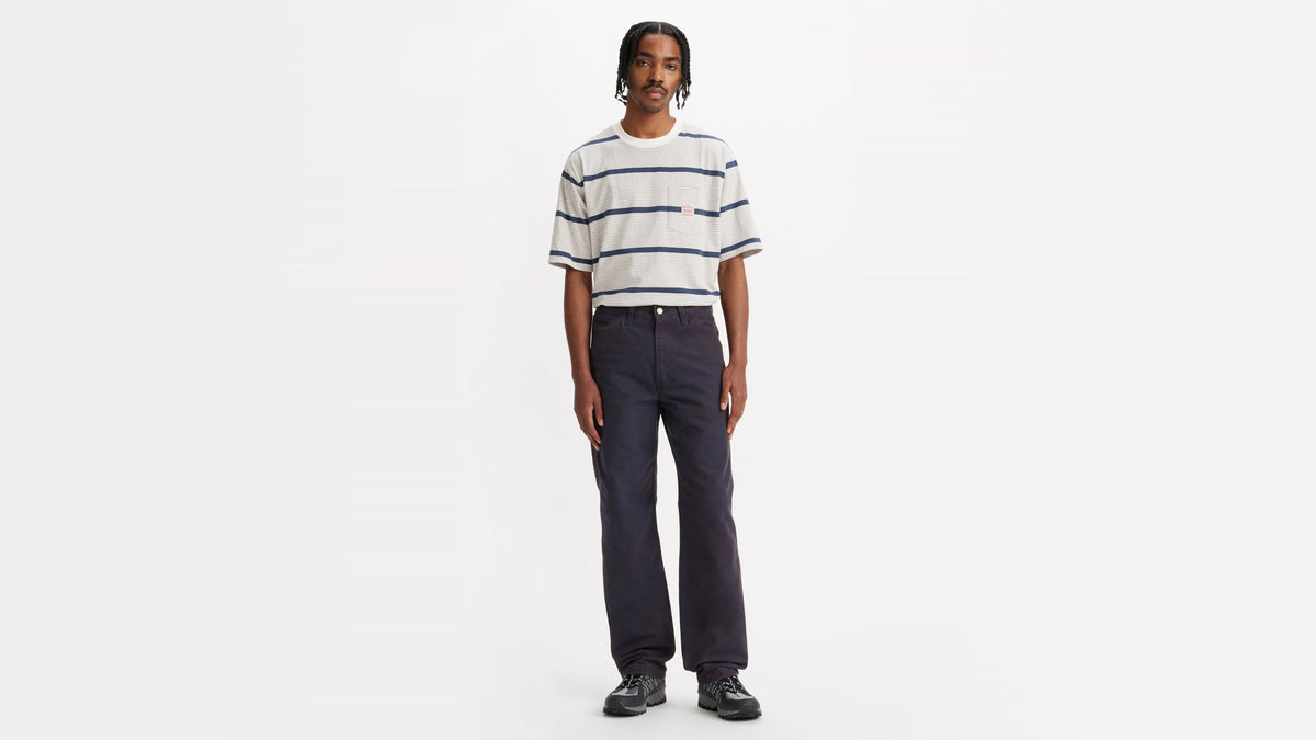 Front view of model in Levi’s striped tee, dark denim jeans, & sneakers