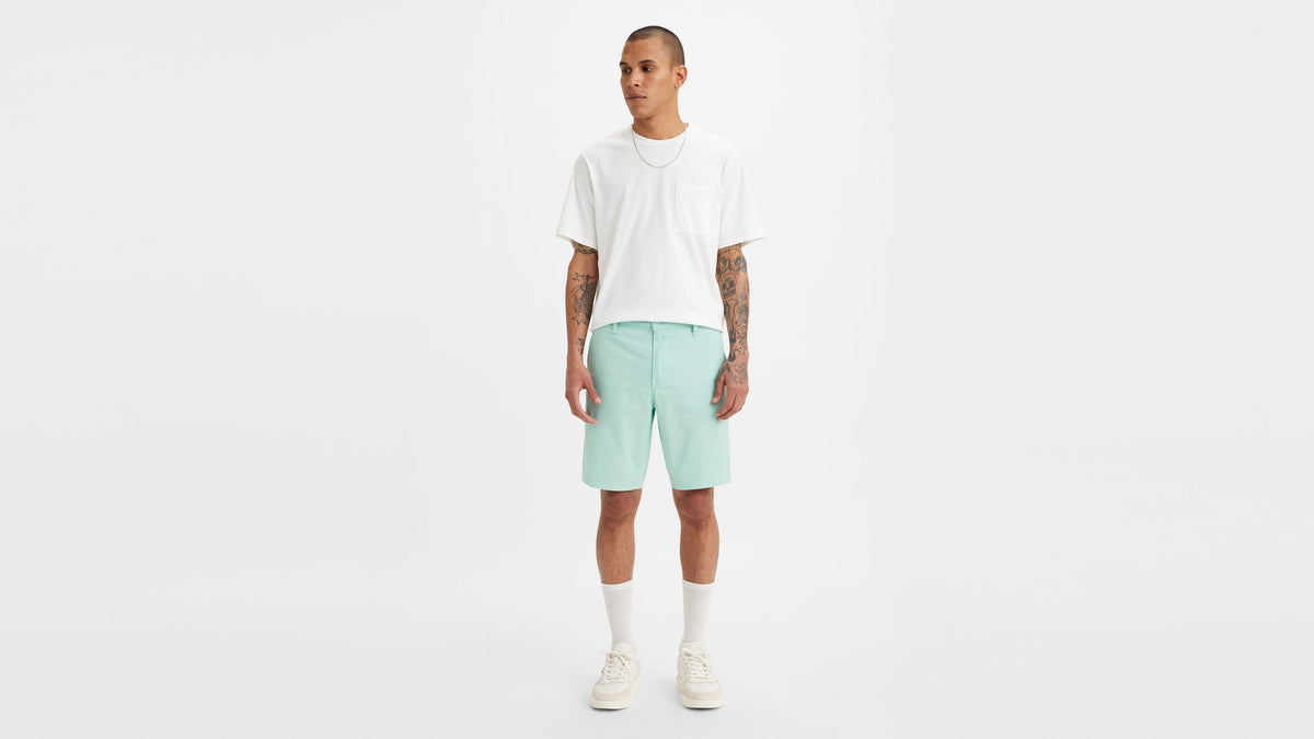 Front view of man in Levi's Chino Shorts in mint green, white T-shirt, & sneakers