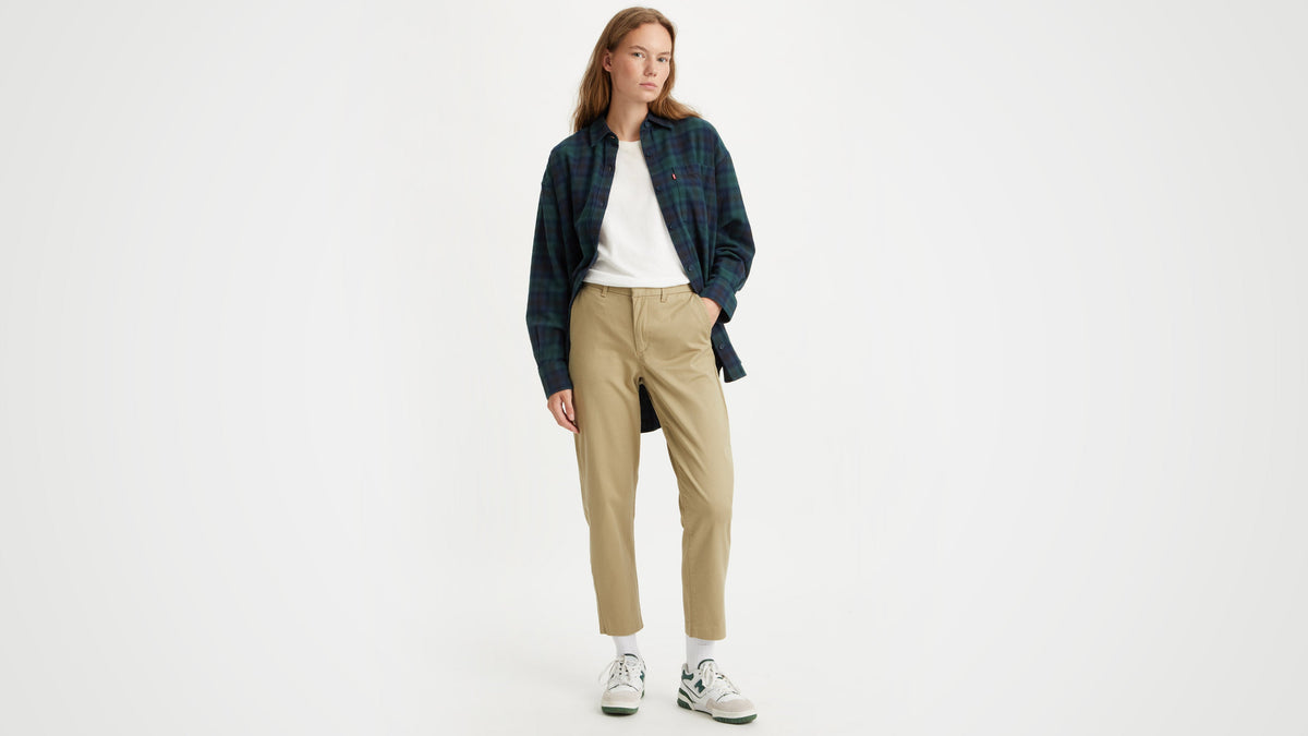 Model in khaki Levi's Women's Essential Chino Pants, white tee, plaid shirt, sneakers