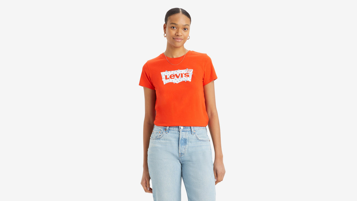 Front view of woman in red Levi’s perfect tee with light wash blue jeans