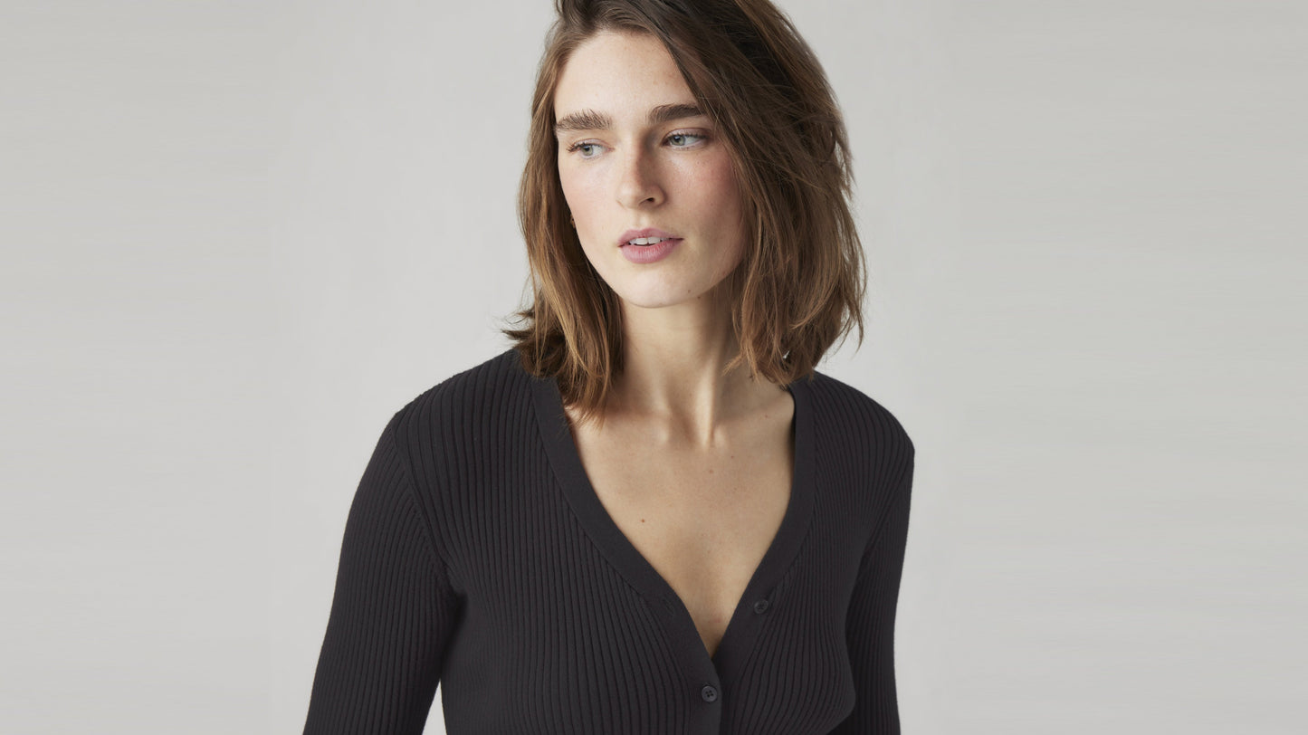 Woman in a deep V-neck black ribbed cardigan