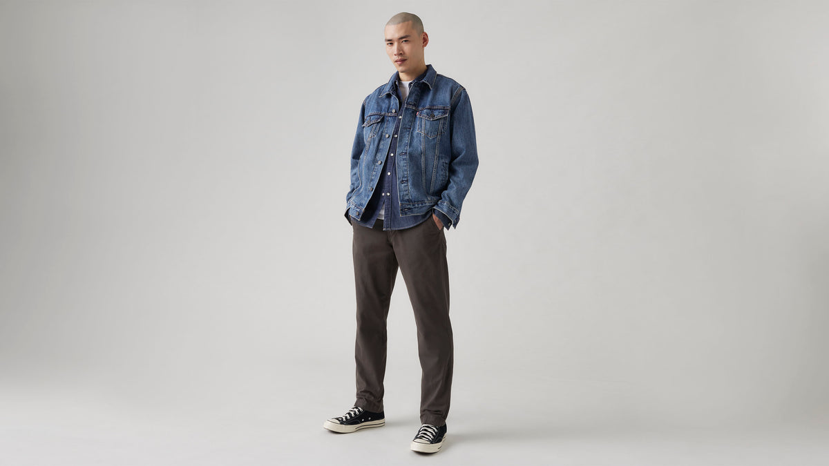 Man in dark brown pants, shirt and denim jacket