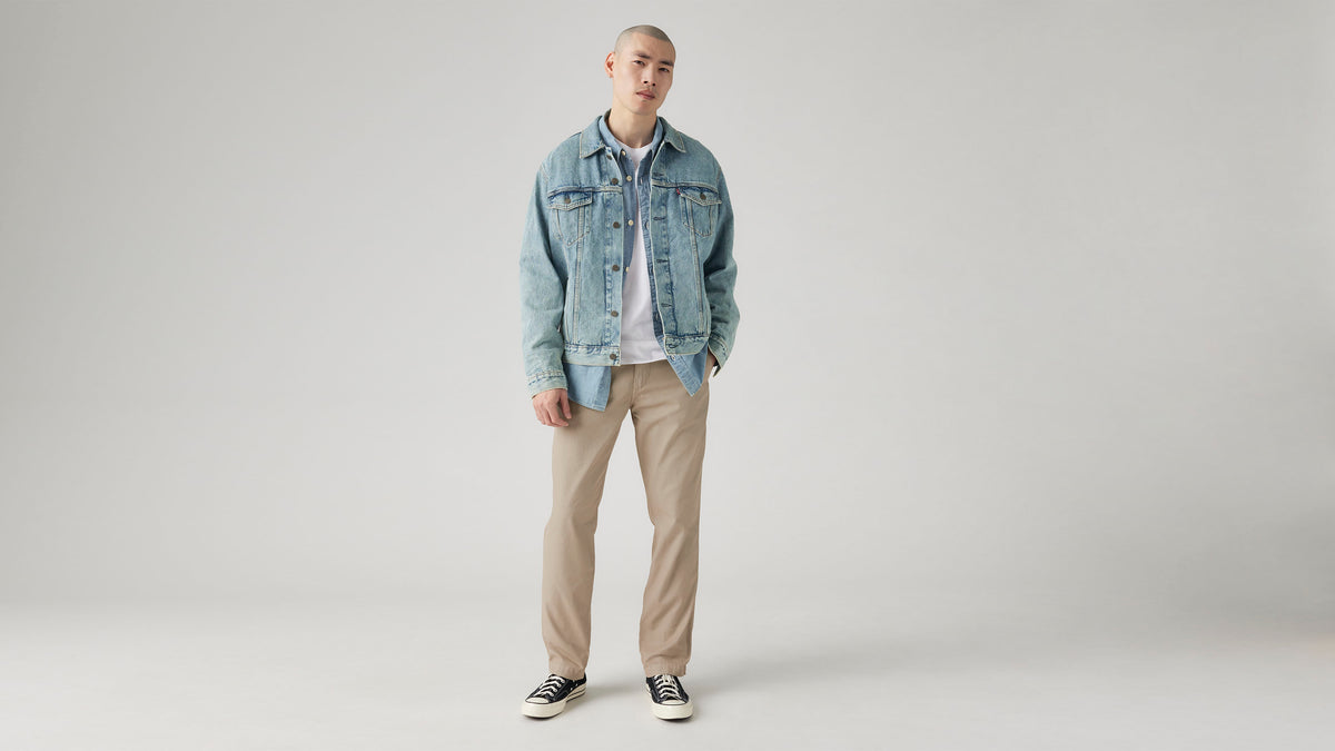 Man in Levi's light-wash denim jacket and beige pants