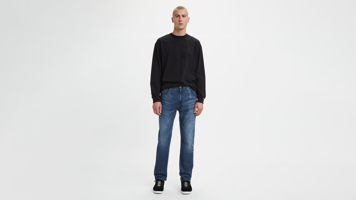 Man in Levi's blue taper fit jeans and black sweatshirt
