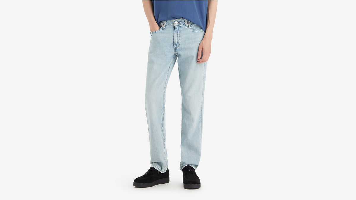 Front view of man wearing Levi's light wash straight-leg jeans with navy tee & black shoes