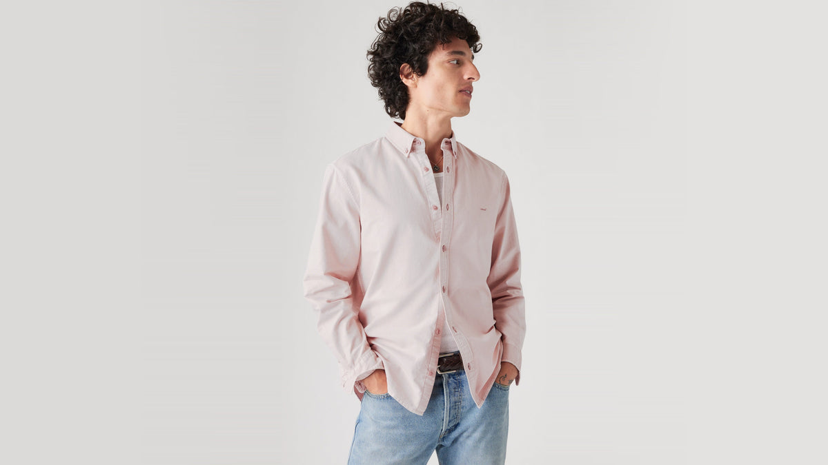 Model in pale pink shirt and jeans