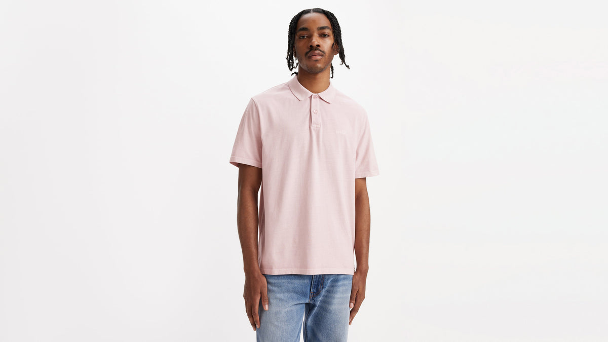 Man in pale pink polo shirt and denim jeans