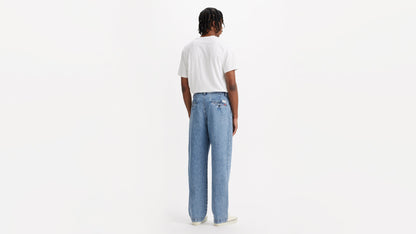 Back view of man in chino loose straight pants and plain tee, hands by his sides
