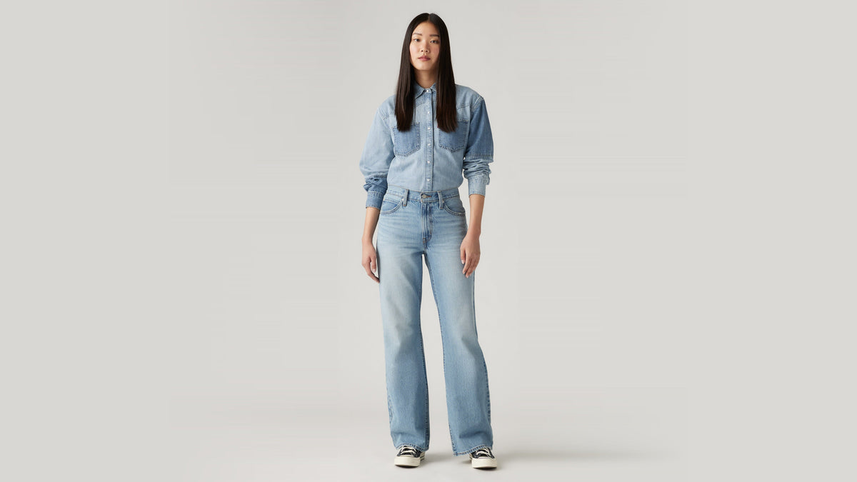 Front view of woman in light denim shirt & light blue Levi's Baggy jeans